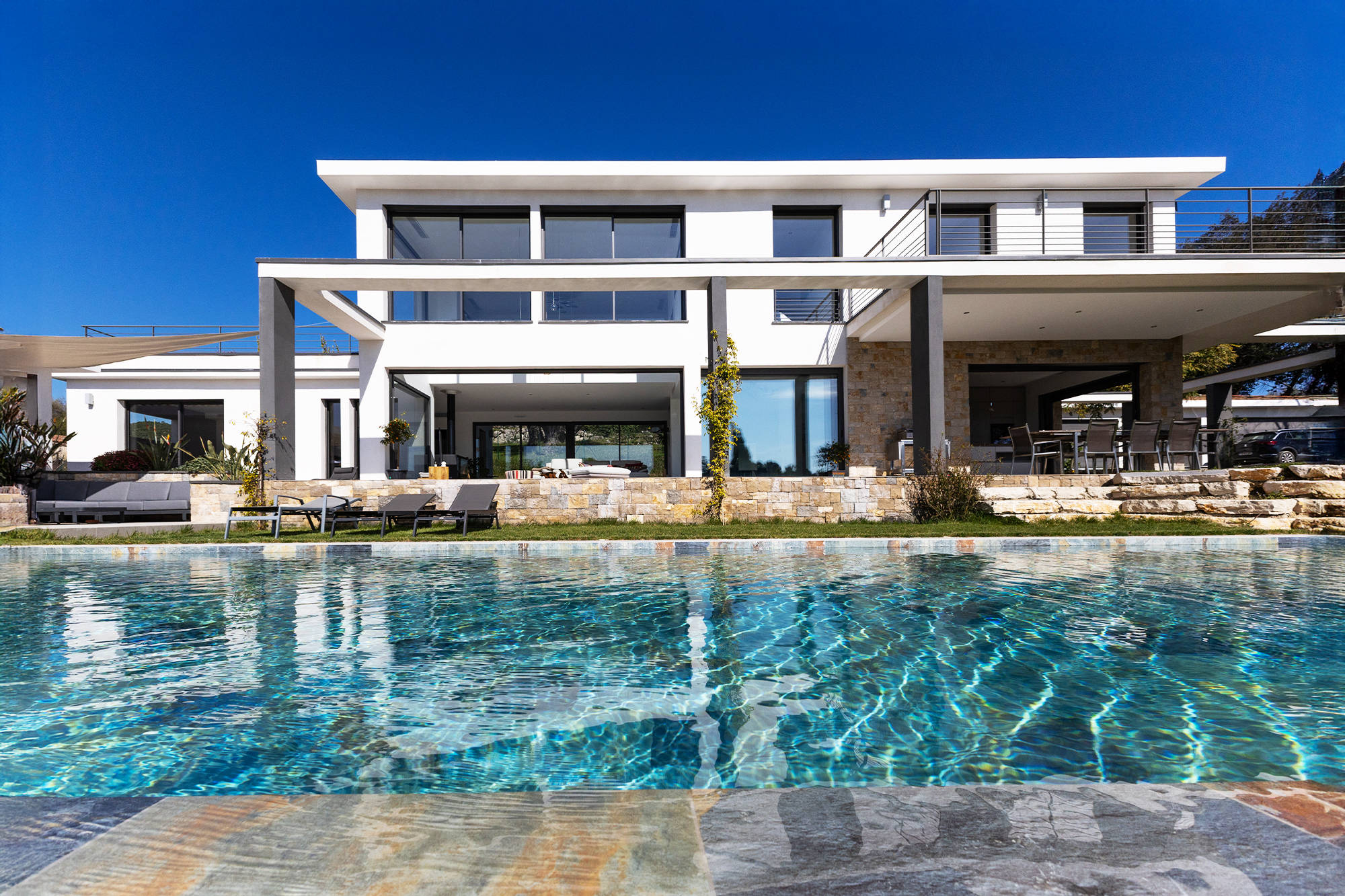 High-end exterior design with shaded terrace and pool.