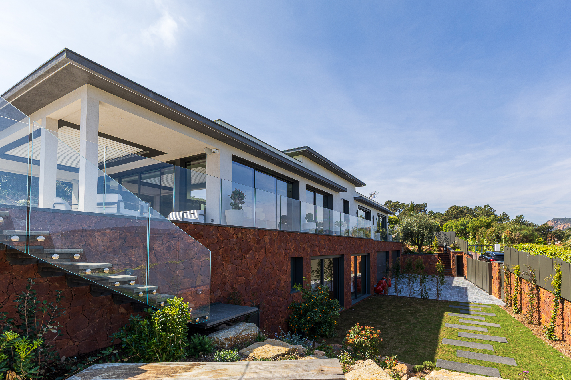 Designer villa exterior with large glass openings and terrace