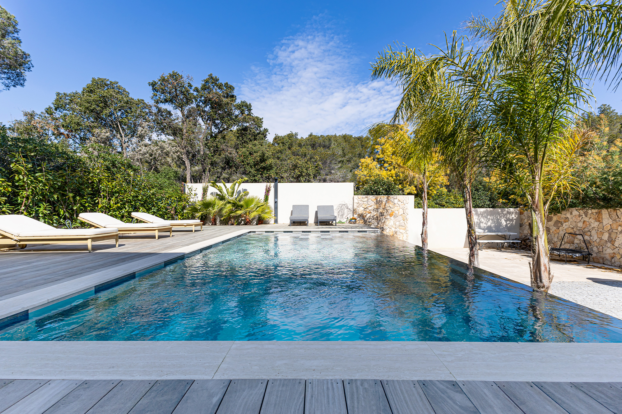 Renovated property with pool and landscaped outdoor area.