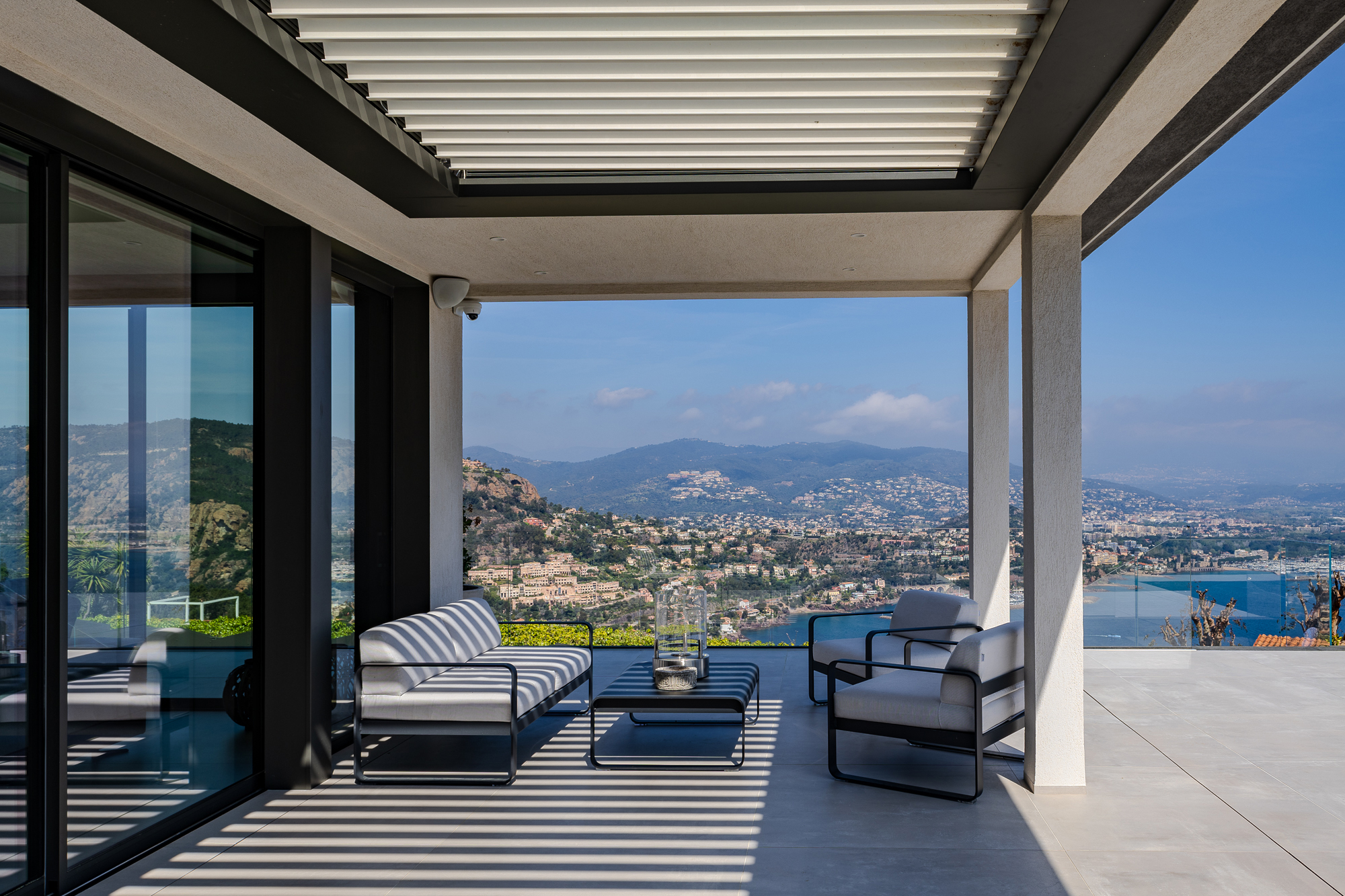 High-end outdoor lounge area with panoramic sea view and shaded terrace